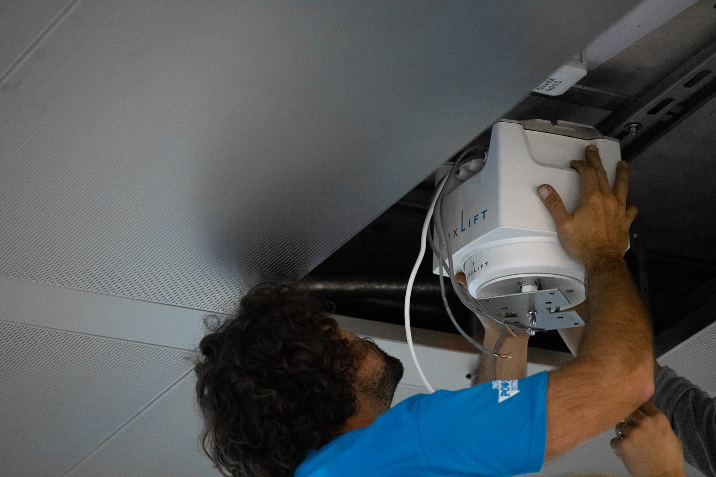 Zwei Arbeiter montieren einen Luxlift Light in der Zwischendecke des Hauptbahnhof Wien.