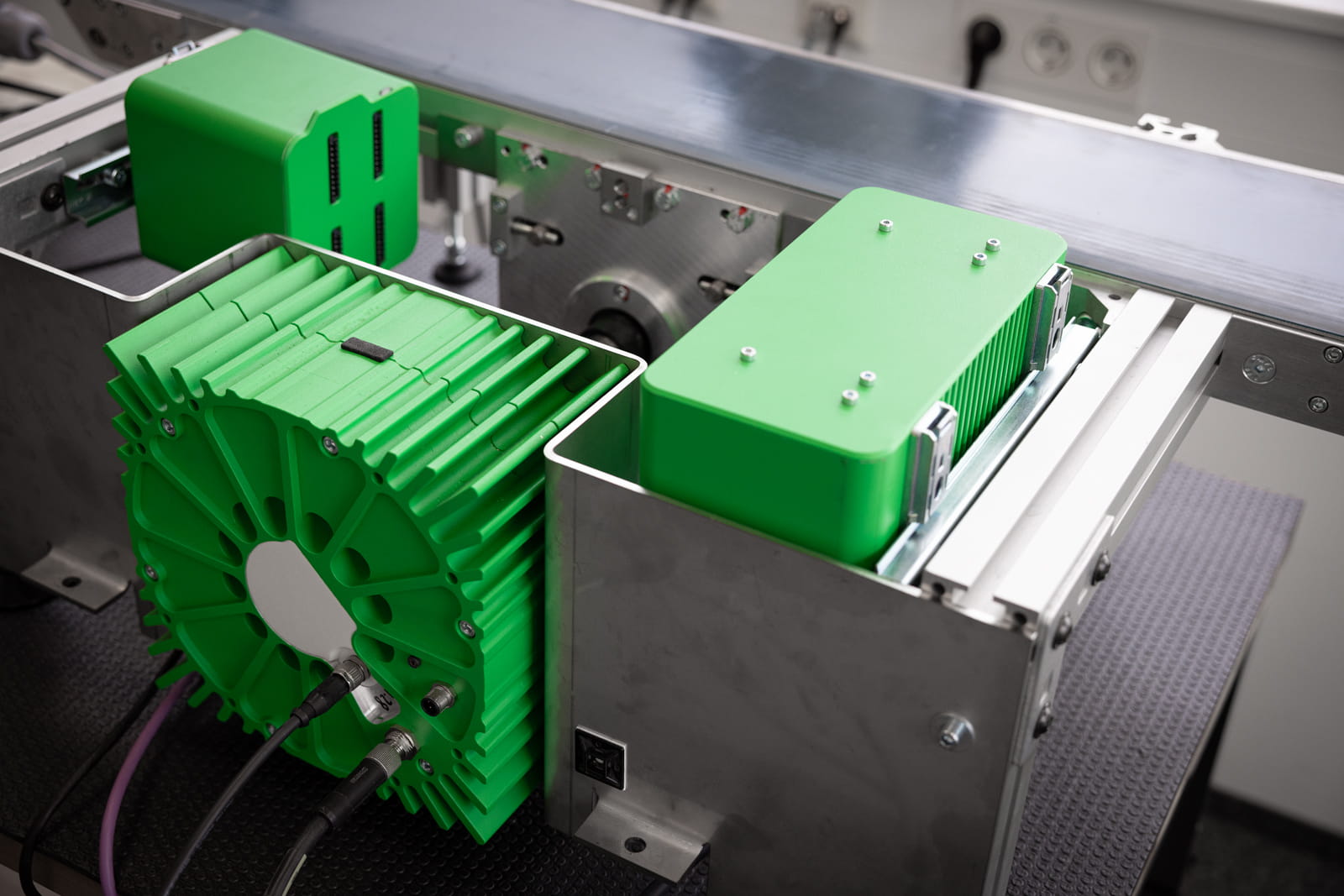 Ein Foto des XOOO Mechatronic Ökosystems. Ein XOOO CC, MC und AXM in leuchtendem Grün.